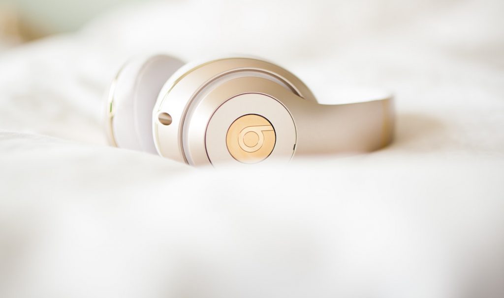 A close up photo of headphones on a bed. Listening to good music is a great way to start your day off right.
