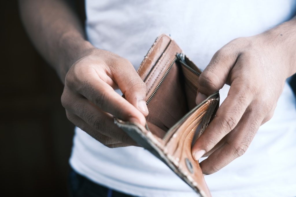 A close-up photo of a person showing their empty wallet.
