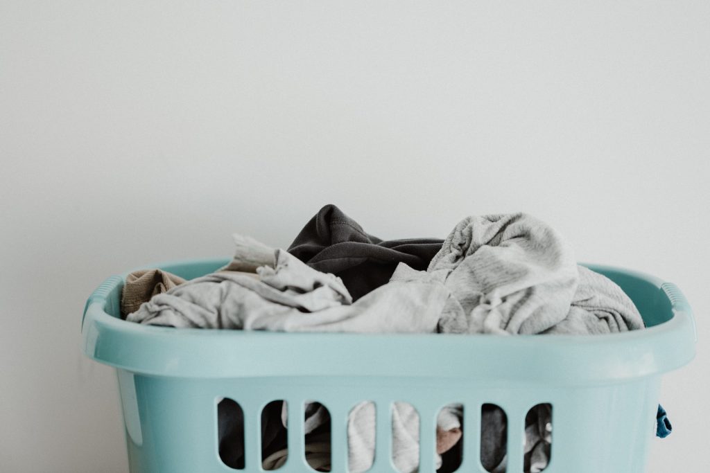 A photo of a laundry basket full of laundry. If you want to know how to wash period underwear, you may be relieved to discover that it can be thrown in with the rest of your laundry!