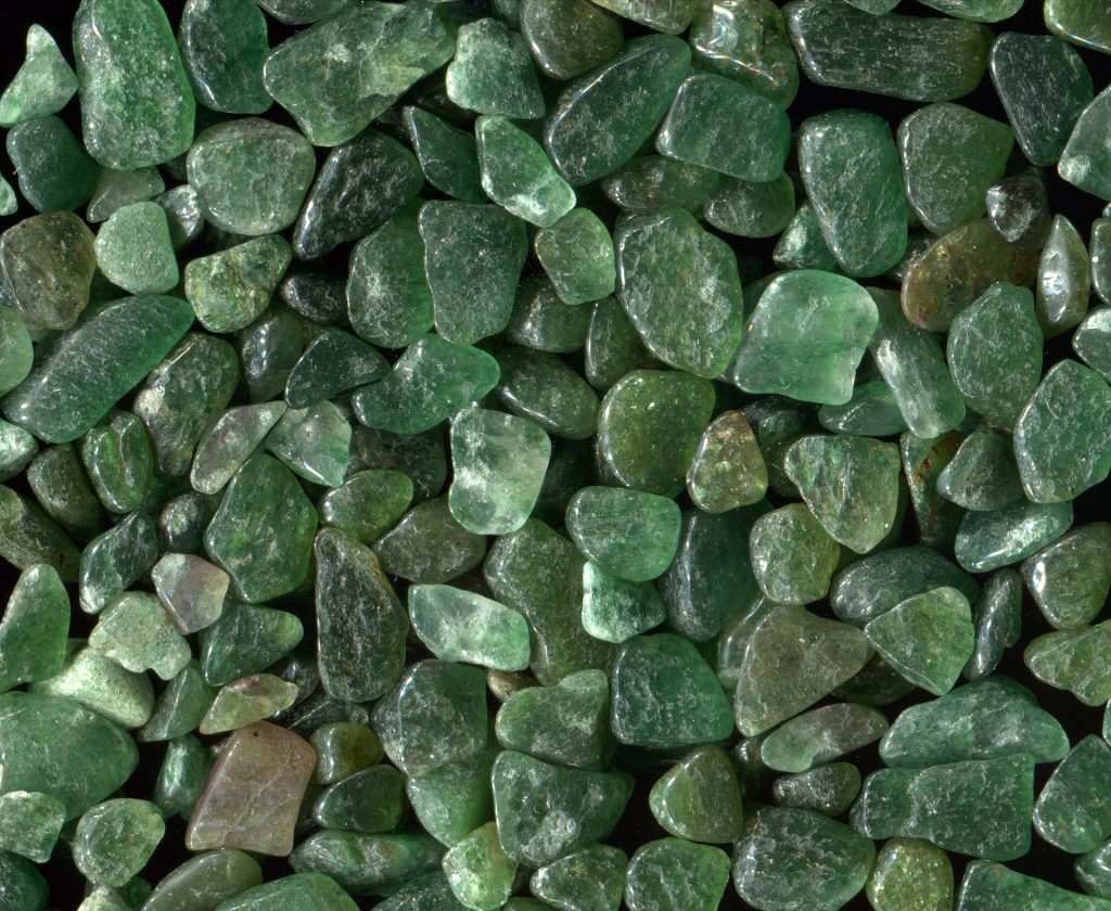A close up photo of a pile of green aventurine stones. Green aventurine affirmations can help with balance and healing.