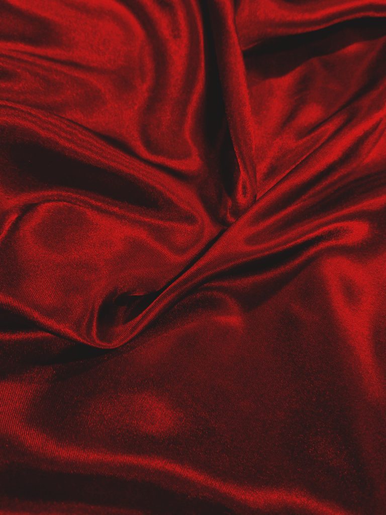 A close up photo of a rich red velvet fabric.