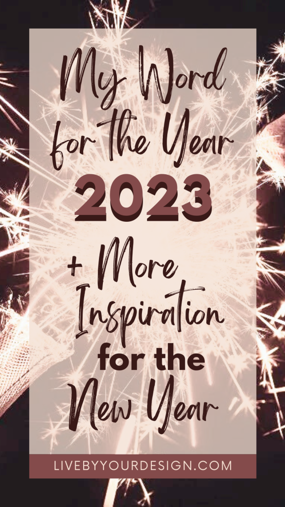 In the background, a photo of a champagne bottle popping with sparks flying behind it. In the foreground, text reads: "My word for the year 2023 plus more inspiration for the new year". Below, highlighted in pink, is the URL to the blog, LiveByYourDesign.com.